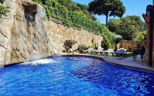 Бассейн у дома с природной каменной стеной