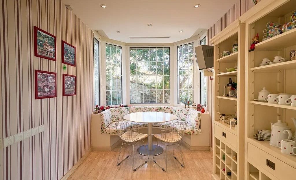 Столовая зона с встроенными полками и большими окнами