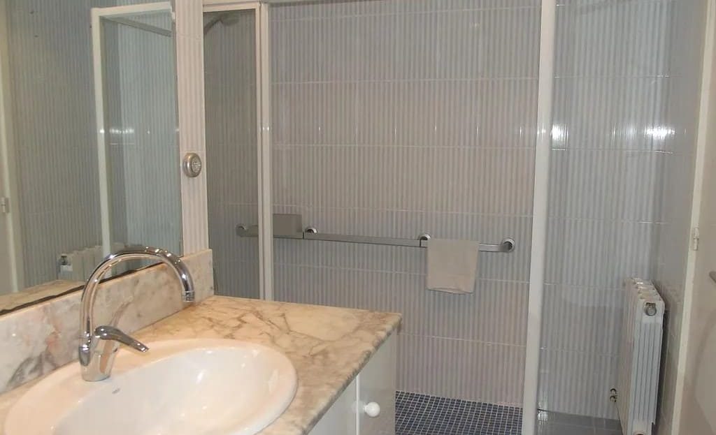 Ванная комната с душевой кабиной и раковиной в квартире в Ситжесе