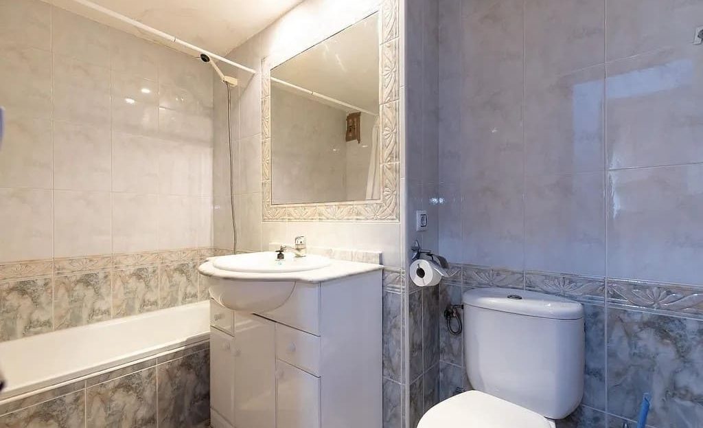 Ванная комната с раковиной, шкафчиком и туалетом.