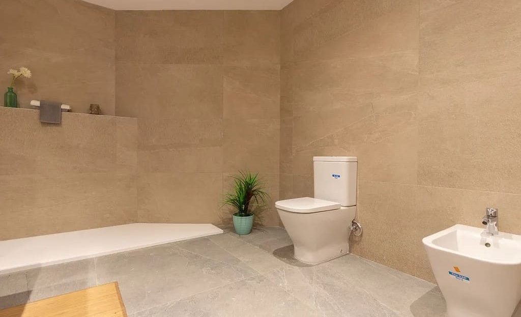Ванная комната с ванной, туалетом и биде в теплых бежевых тонах