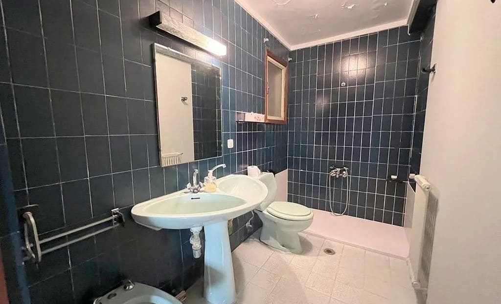 Ванная комната с душем и тёмной плиткой