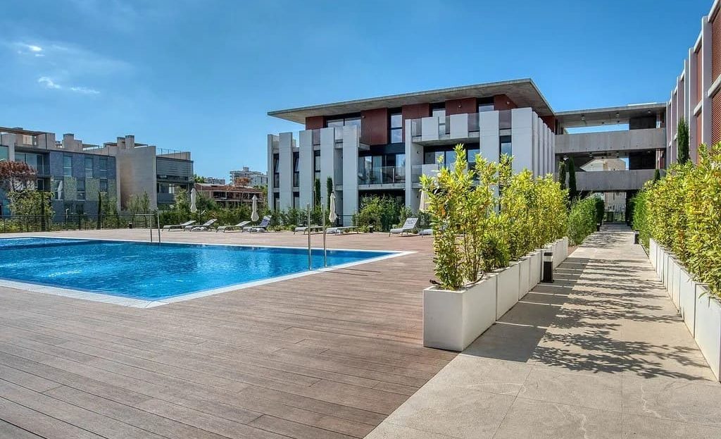 Общий вид жилого комплекса с большим бассейном и зоной отдыха