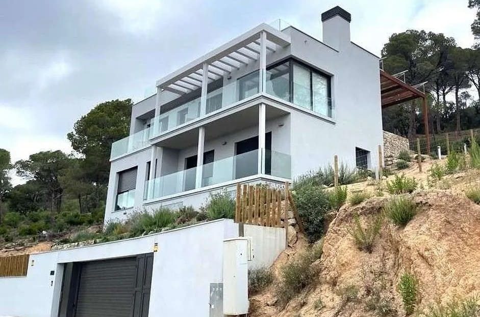 Современная вилла с террасами и гаражом, вид с улицы.