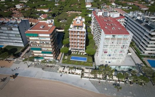 Аэрофото ряда жилых зданий у пляжа в Плая-де-Аро, центральное здание — новостройка
