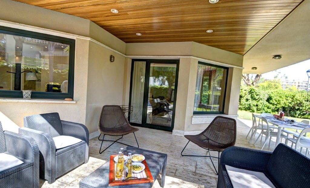 Крытая терраса с лаунж-зоной и видом на сад