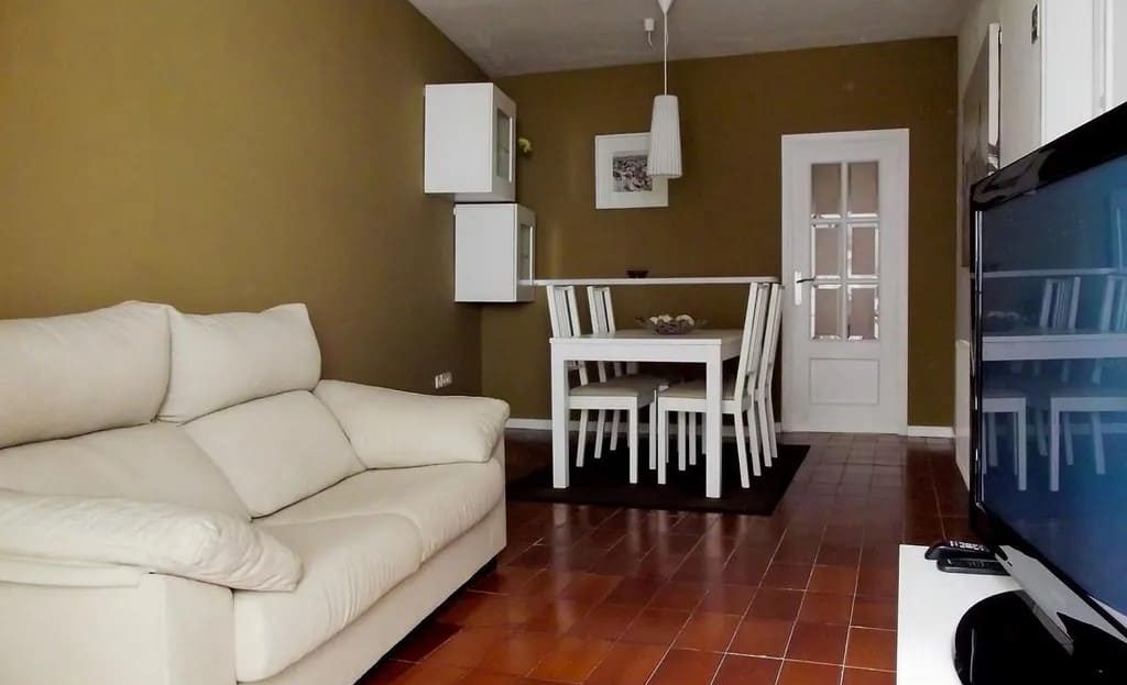 Просторная гостиная с диваном и обеденным столом в квартире на улице Эспальтер