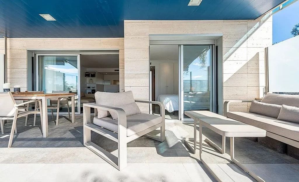 Просторная крытая терраса с мягкой мебелью и выходом в квартиру.