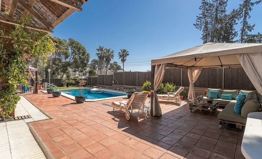 Терраса с навесом и лаунж-зоной рядом с бассейном