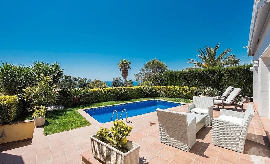 Сад и бассейн с видом на море.