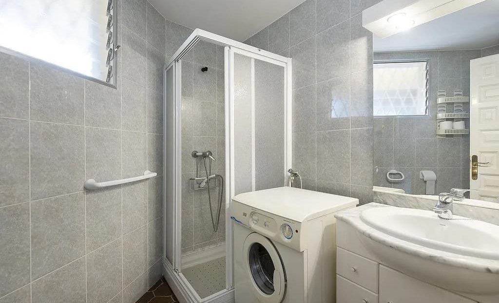 Ванная комната с душевой кабиной, раковиной и стиральной машиной