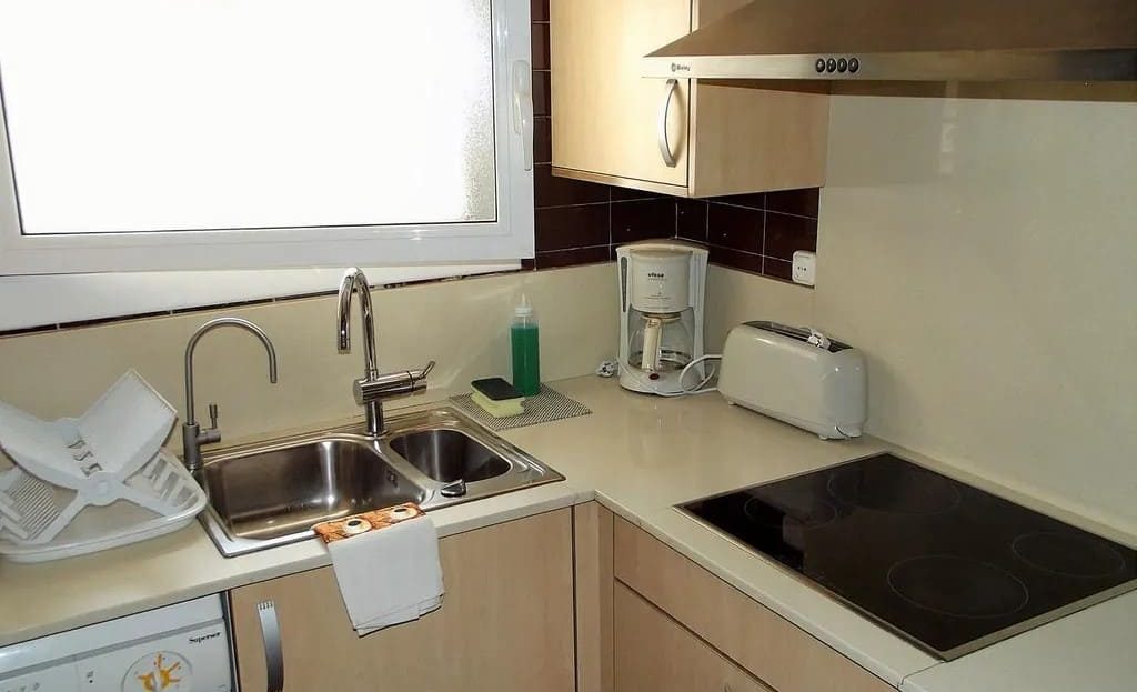 Полностью оборудованная кухня с рабочей поверхностью в городской квартире