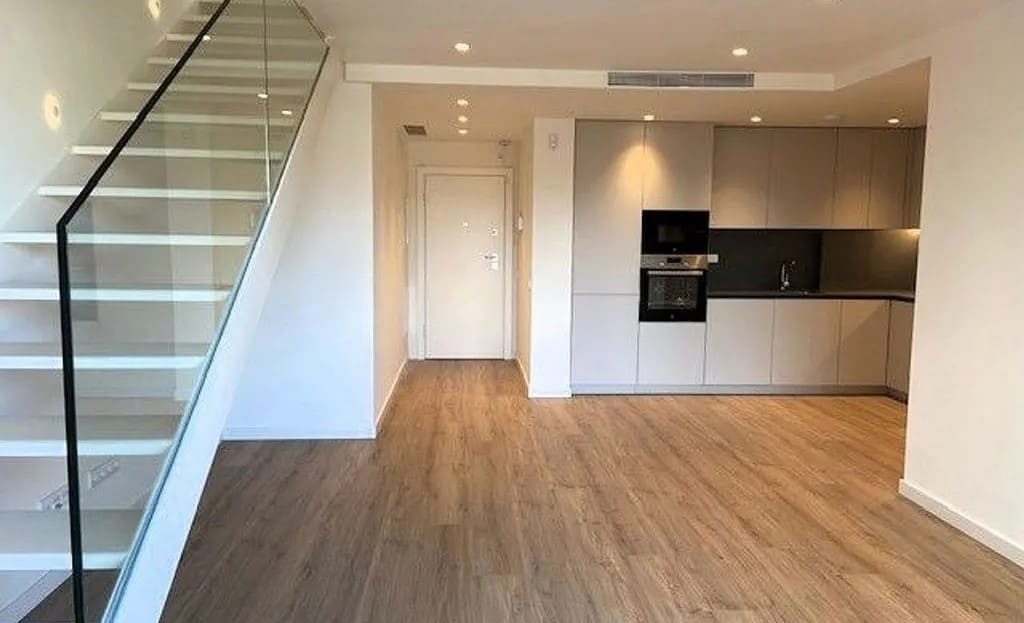 Гостиная с лестницей на верхний уровень и кухней открытой планировки