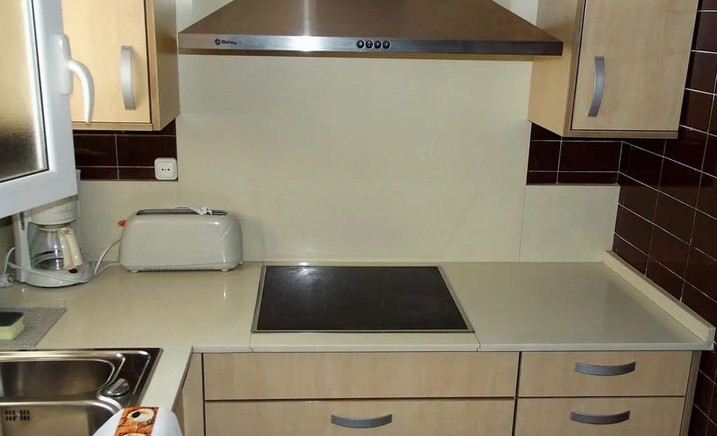 Кухня с бытовой техникой и вытяжкой в квартире на продажу в Ситжесе