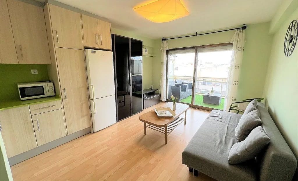 Гостиная с кухней, диваном и выходом на балкон