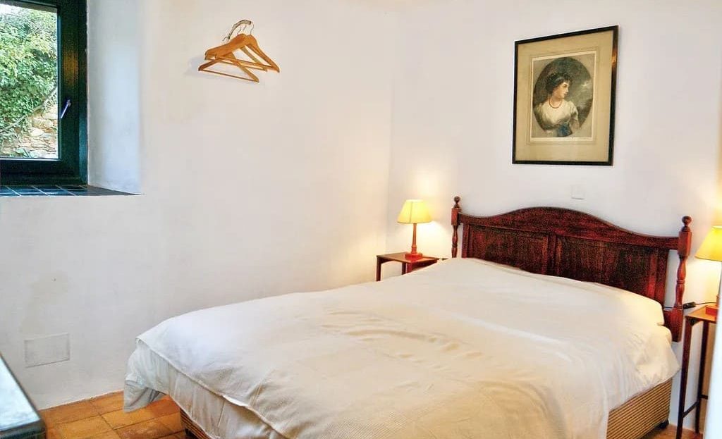 Двухместная спальня с каменными элементами и видом в сад