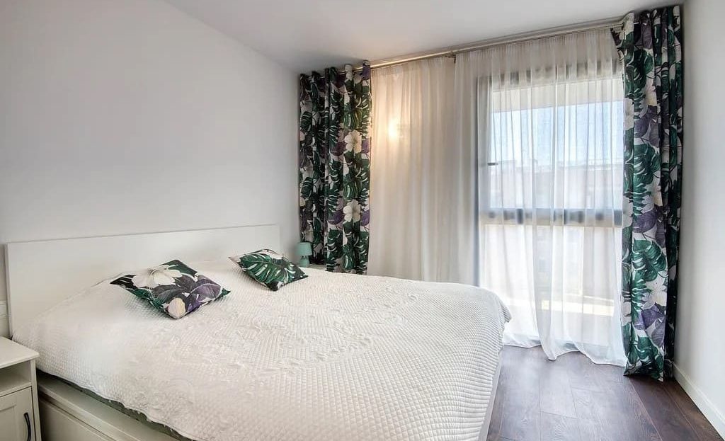 Спальня с большим окном в современной квартире