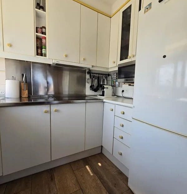 Отдельная кухня с белой мебелью и бытовой техникой