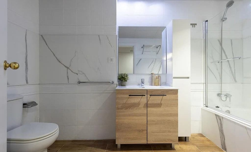 Ванная комната с ванной, мраморной отделкой и современной мебелью.