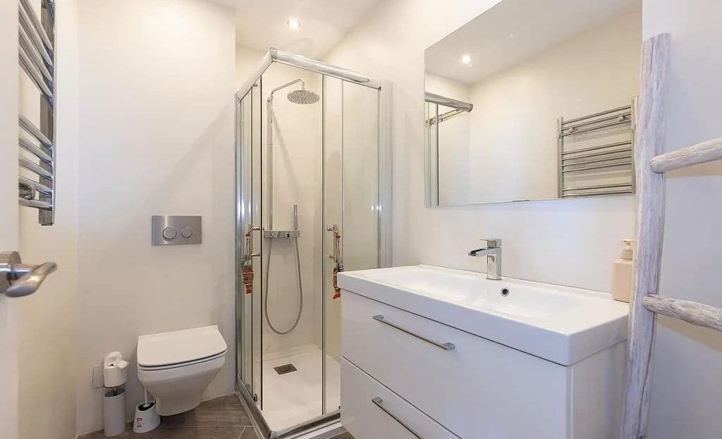 Современная ванная комната с душевой кабиной и раковиной.