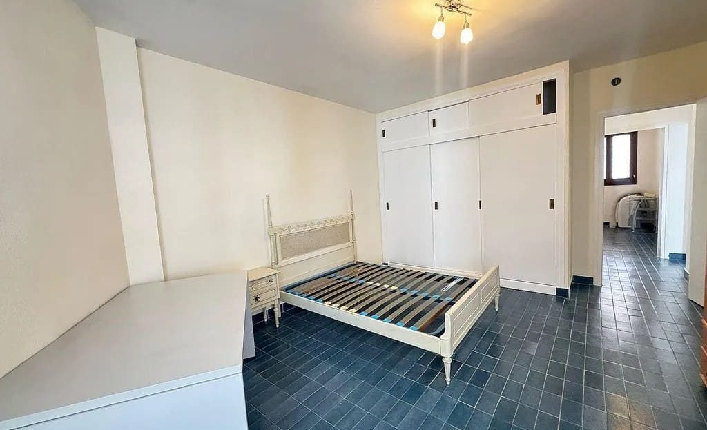 Двухместная спальня с кроватью, шкафами и окном.