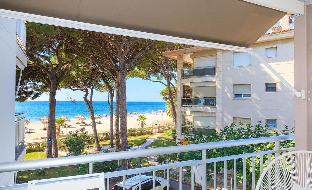 Вид с террасы через сосны на пляж и Средиземное море.