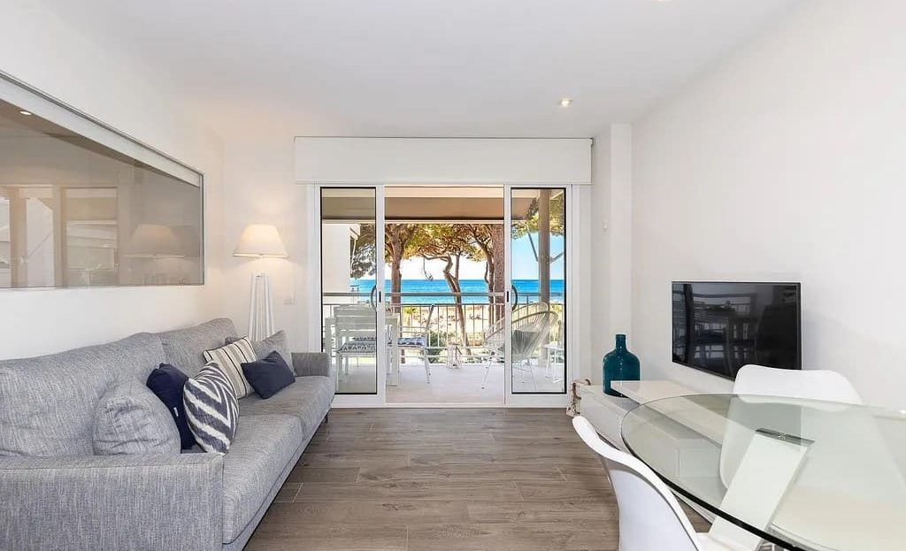 Гостиная-столовая с большими окнами и морским пейзажем.