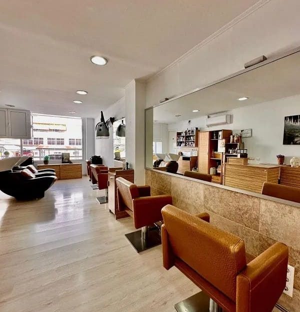 Зал парикмахерской с клиентскими креслами и зоной ожидания