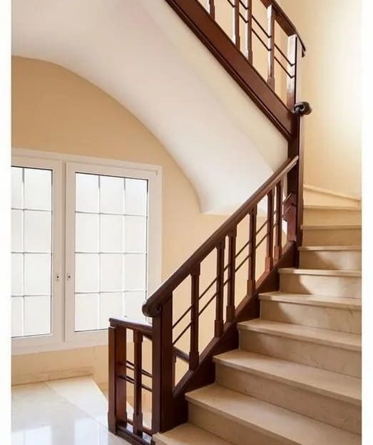 Лестничный пролет с деревянными перилами и большими окнами