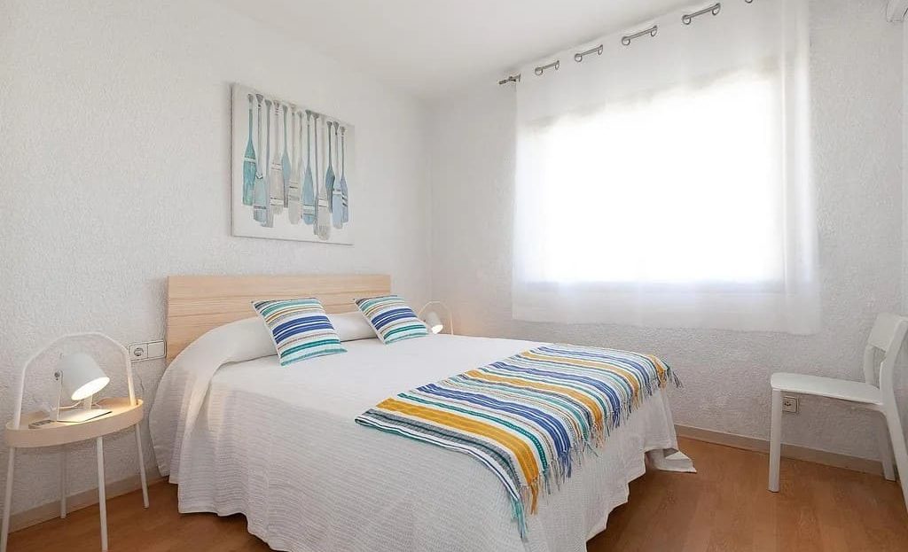 Главная спальня с двуспальной кроватью и естественным освещением.