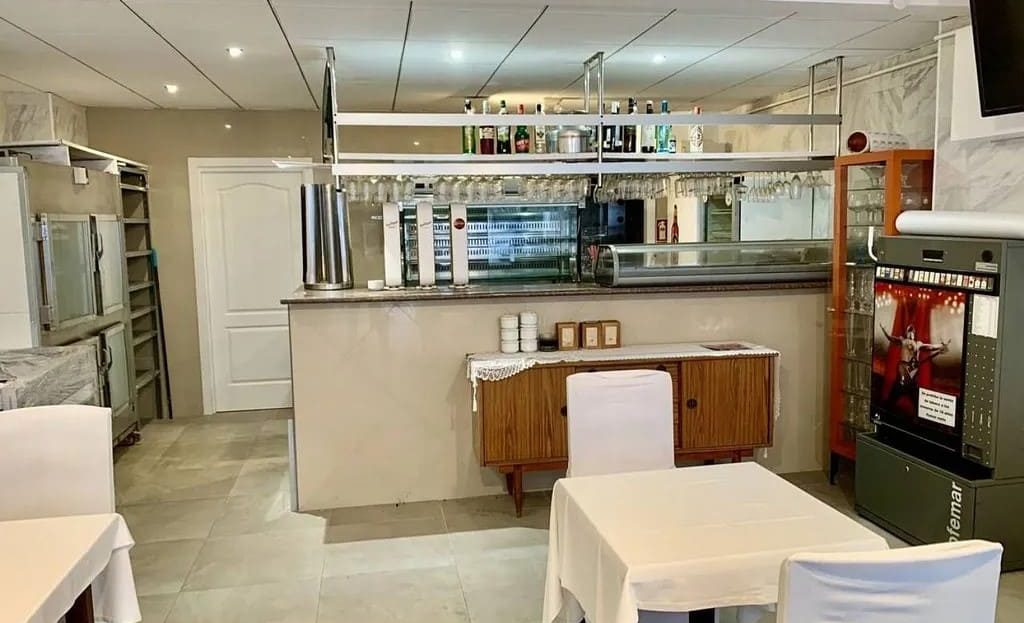 Интерьер ресторана с барной зоной и открытой кухней