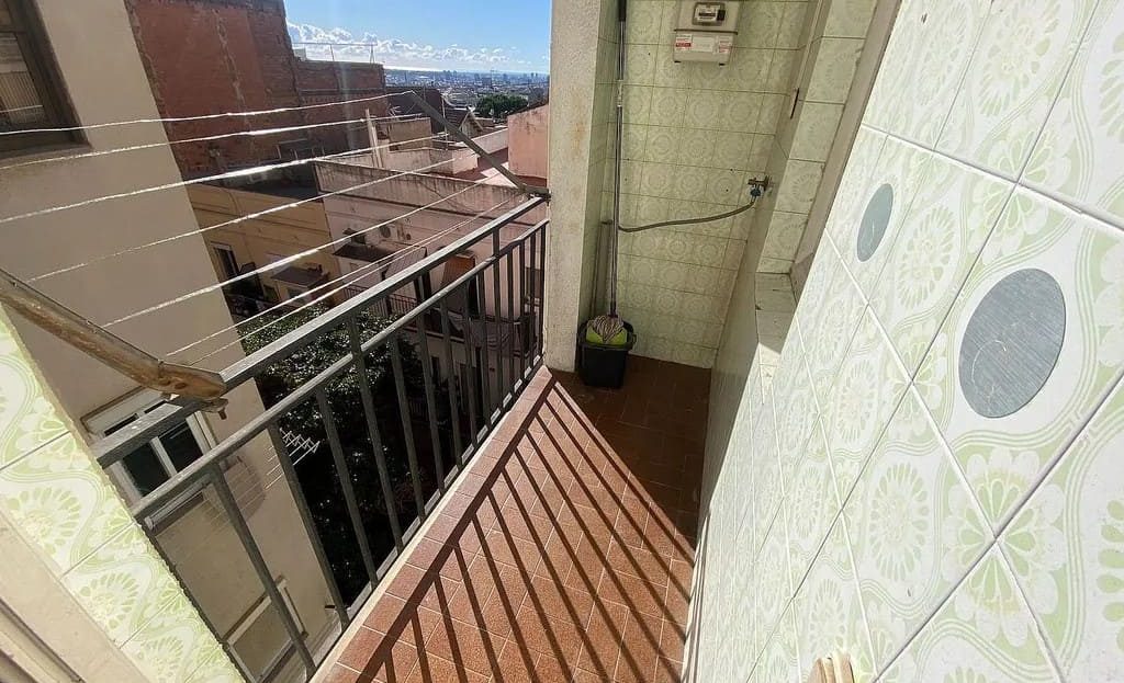 Балкон квартиры с видом на открытое пространство и соседние здания