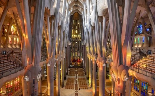 Высокий центральный неф храма с колоннами и разноцветным светом витражей