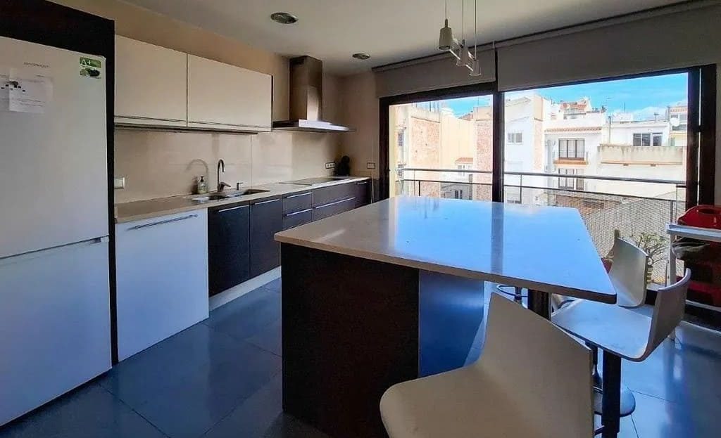 Кухня с островом, встроенной техникой и выходом на улицу через большие окна.