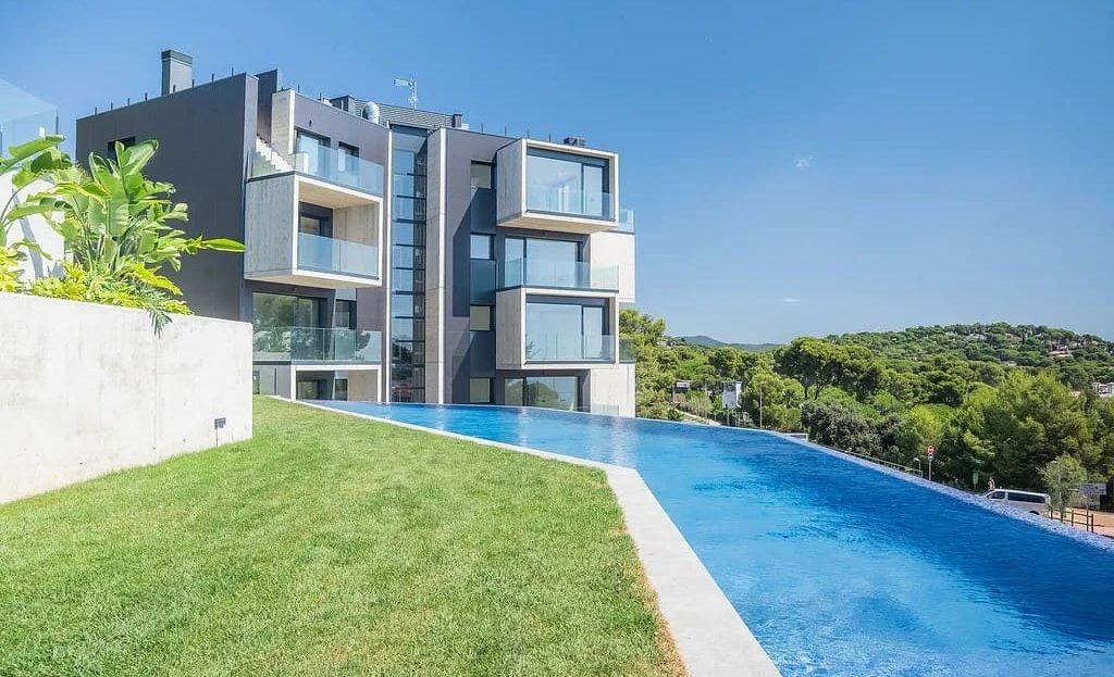 Фасад современного жилого комплекса с бассейном в Сан-Антонио-де-Калонже