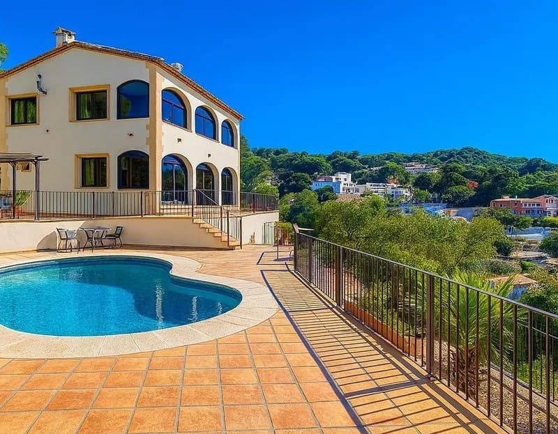 Терраса виллы с бассейном и панорамным видом на город и горы.