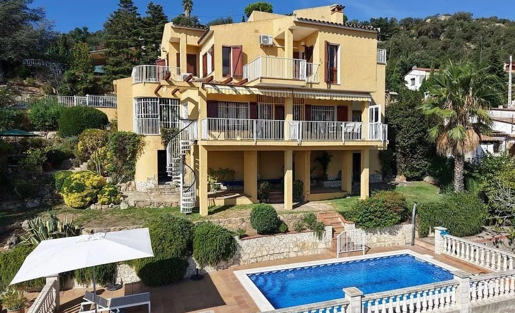 Фасад виллы с бассейном и садом.