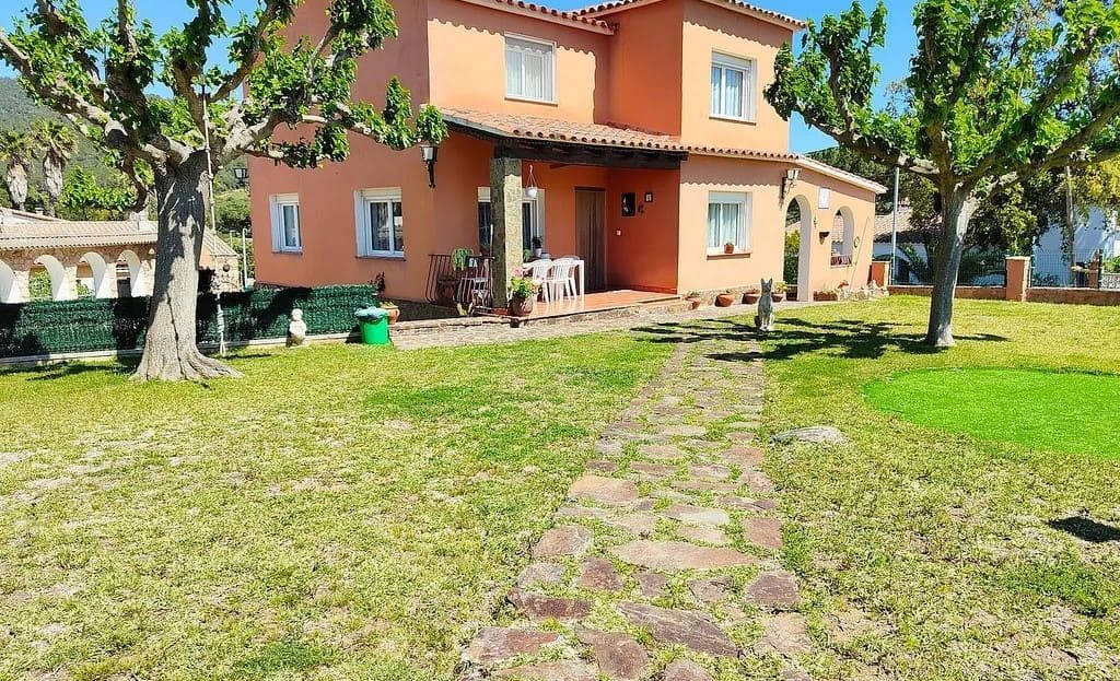 Фасад дома с большим зелёным участком.