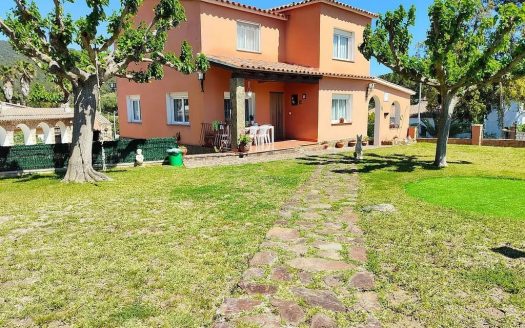 Фасад дома с большим зелёным участком.