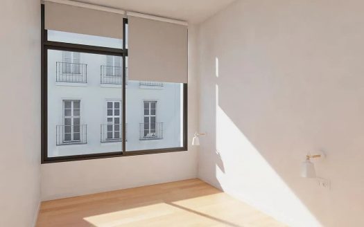 Светлая комната с большим окном и деревянным полом.