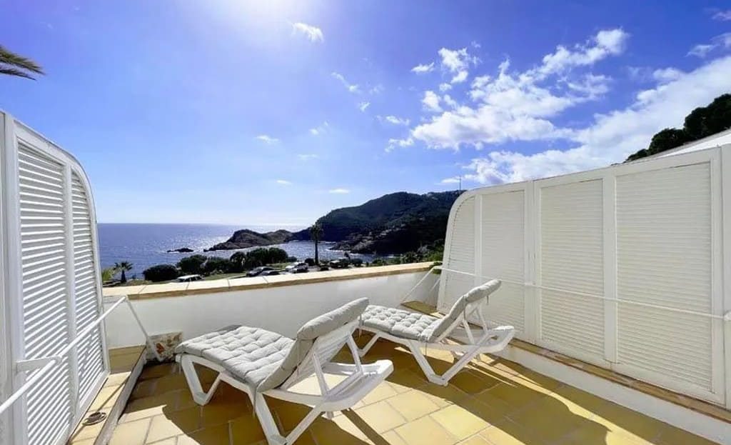 Терраса с шезлонгами и панорамным видом на море и побережье.