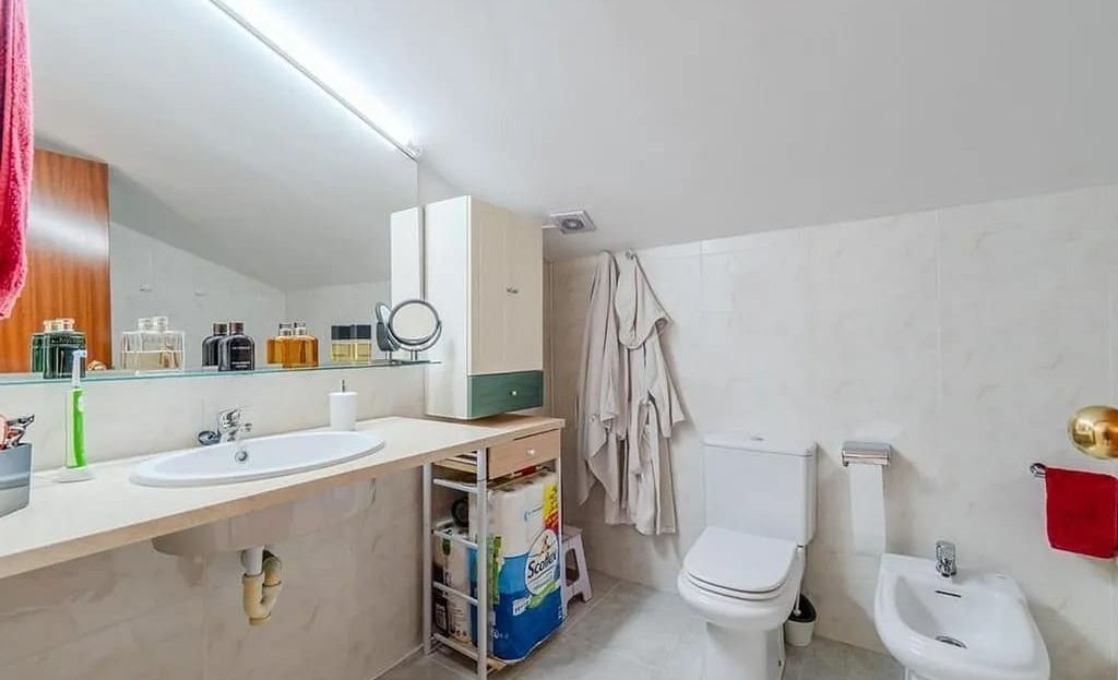 Ванная комната с умывальником, биде и душевой зоной под наклонным потолком