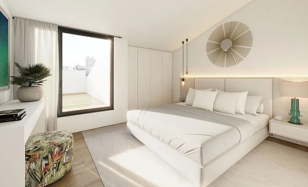 Светлая спальня с большой кроватью и выходом на балкон.