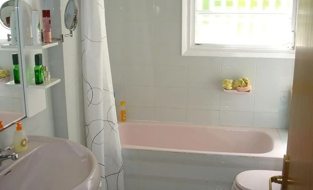 Ванная комната с ванной и окном, светлая плитка