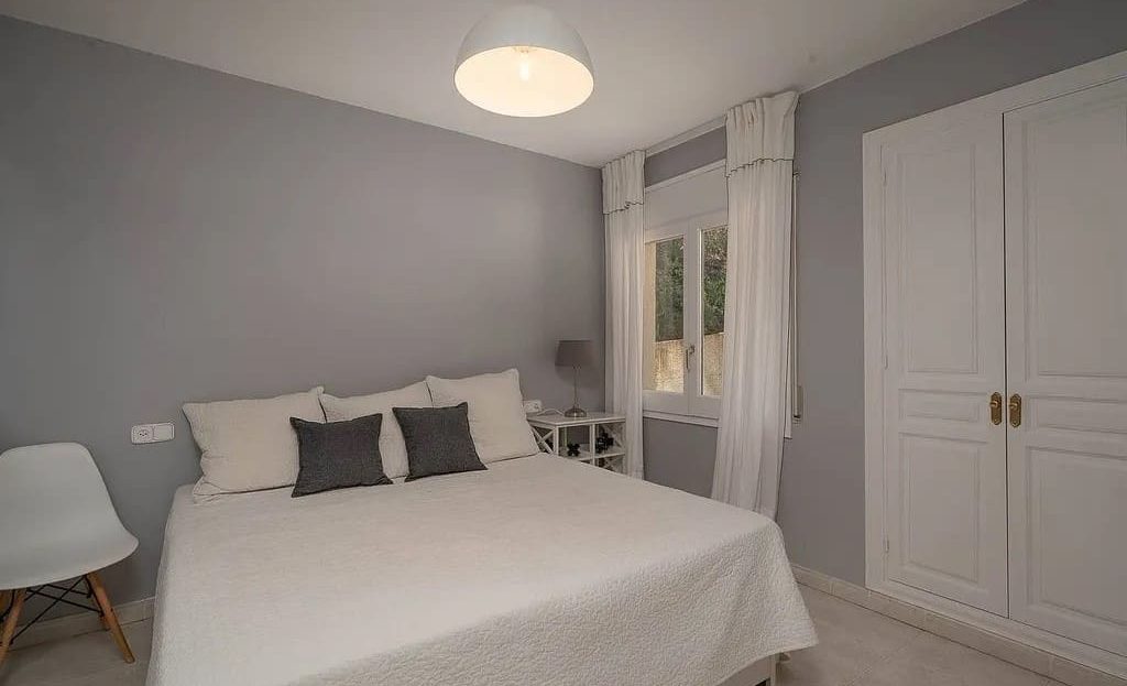 Спальня в светлых тонах с двуспальной кроватью.