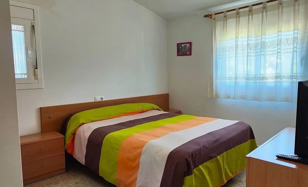 Спальня с двуспальной кроватью и большим окном.