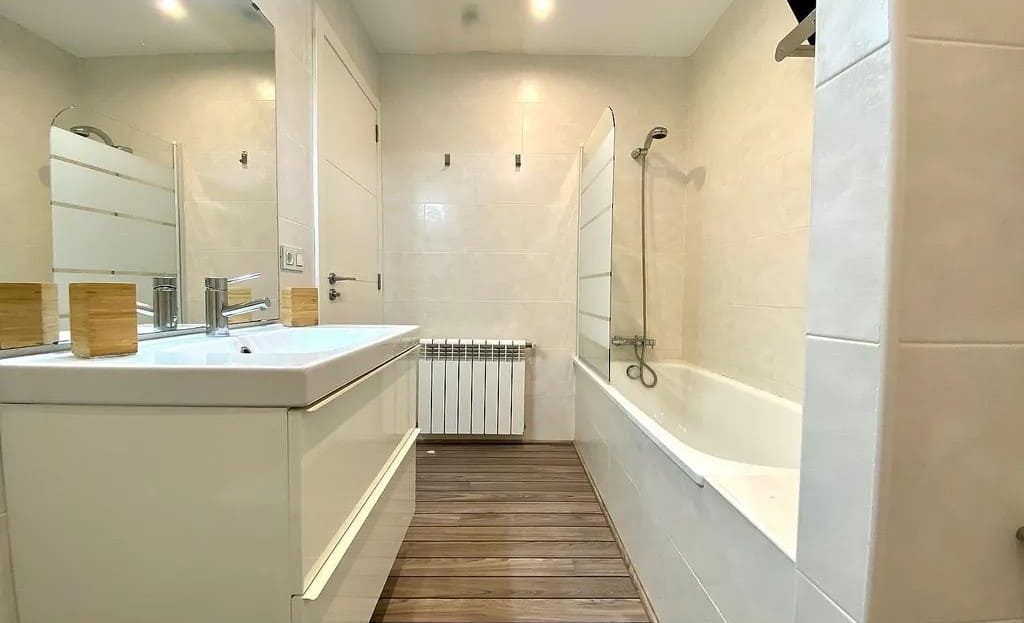 Современная ванная комната с ванной и двойной раковиной.