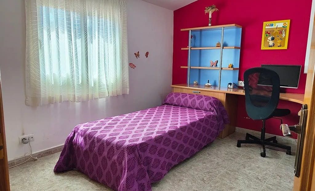 Спальня с рабочей зоной и односпальной кроватью.