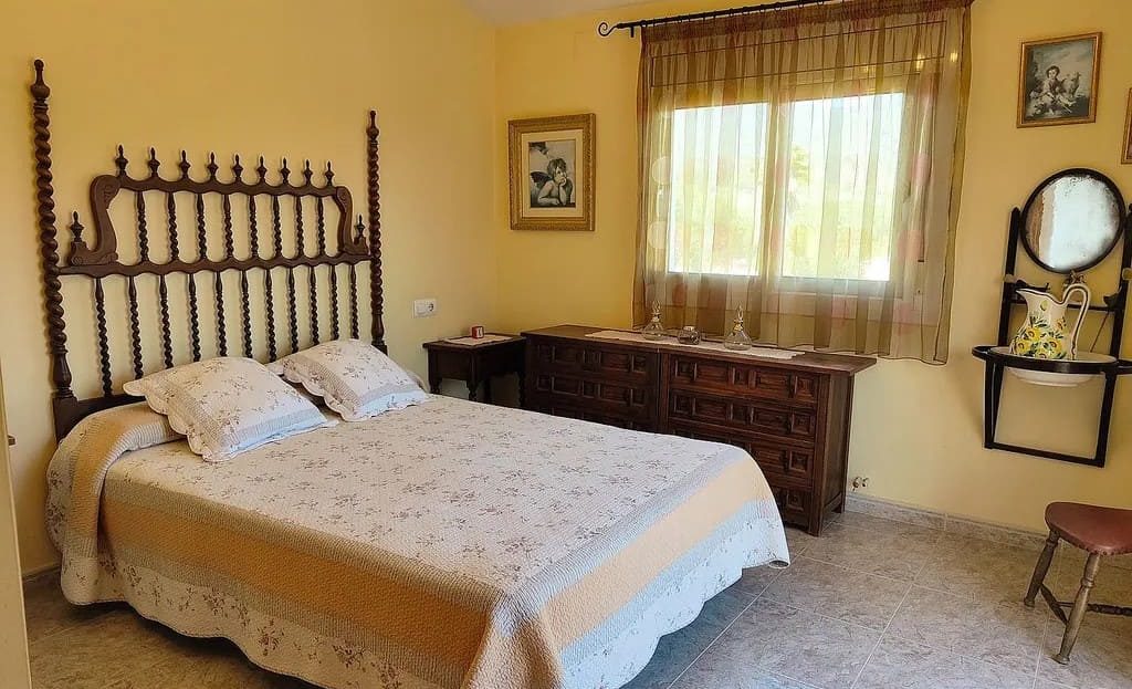 Спальня в тёплых тонах с двуспальной кроватью.