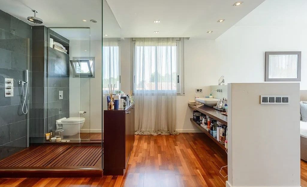 Большая ванная комната с душевой кабиной и панорамным стеклянным блоком.